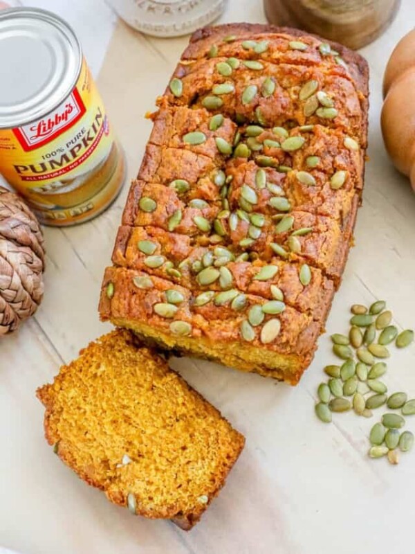 Pumpkin bread with pumpkin seeds on a cutting board.