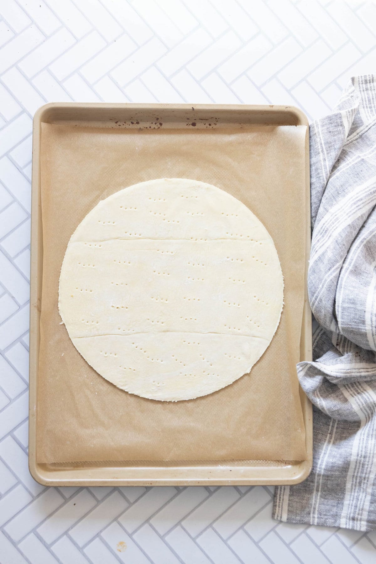 A sheet of dough next to a towel with Easy French Apple Tarts.