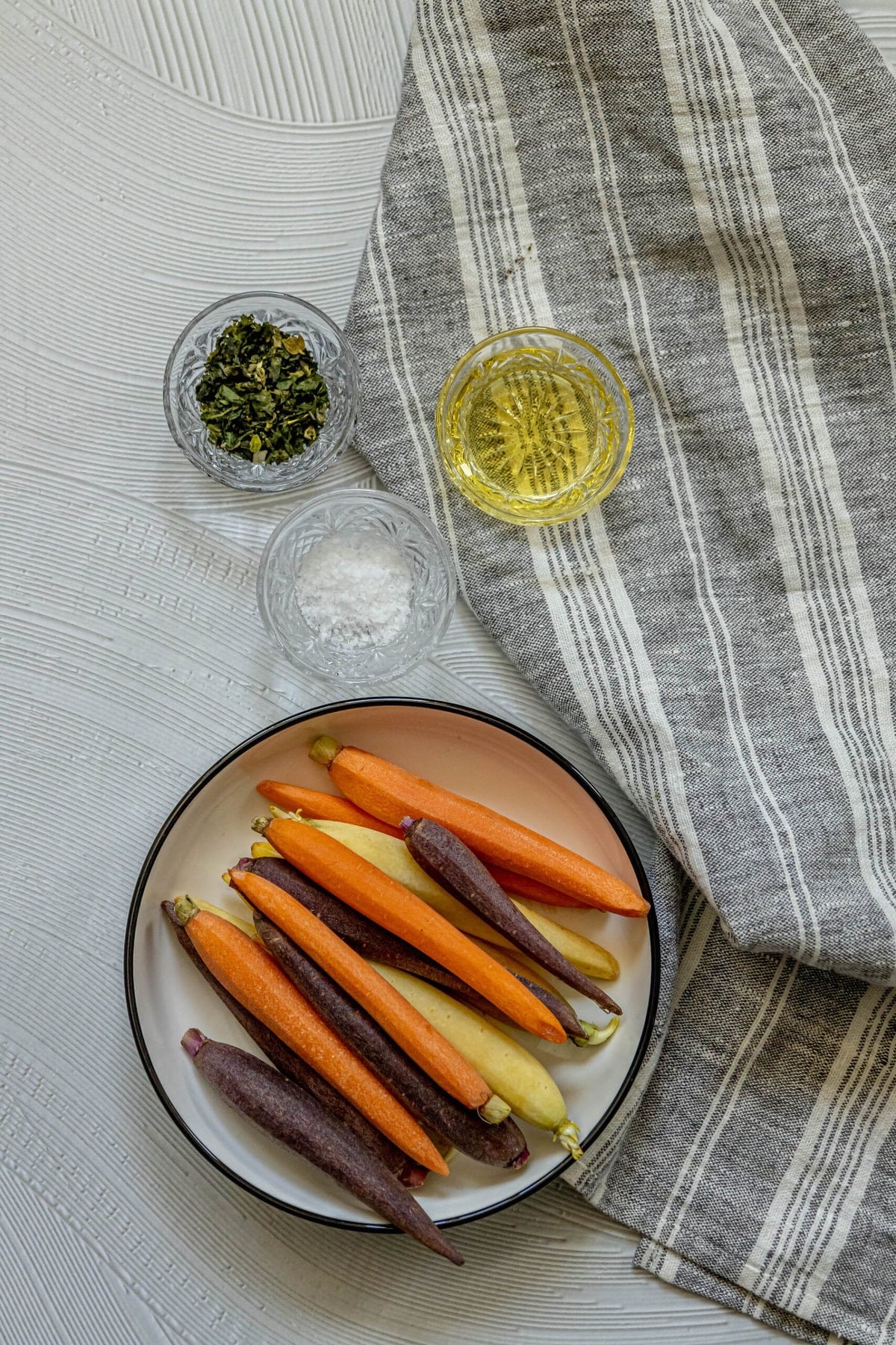 A plate of herbed grilled carrots on a table.