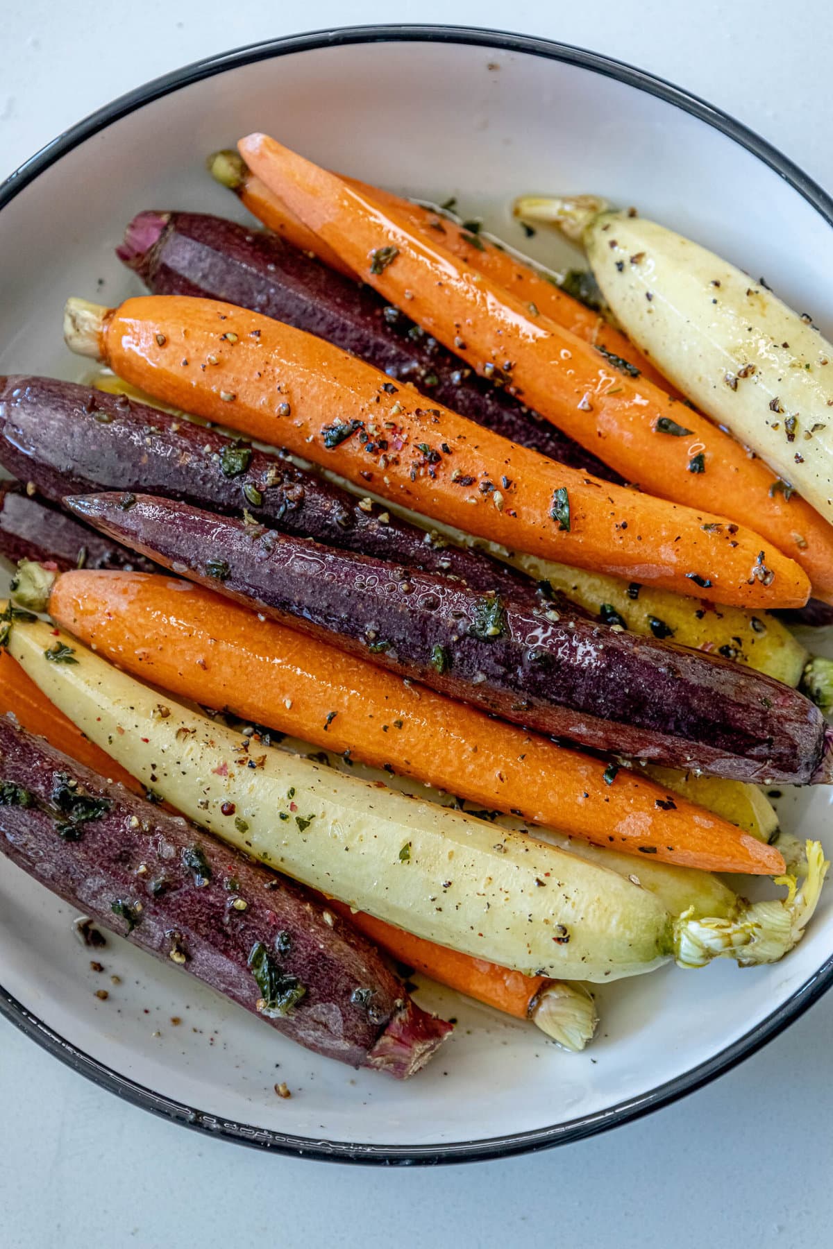Grilled carrots on a plate with herbs.