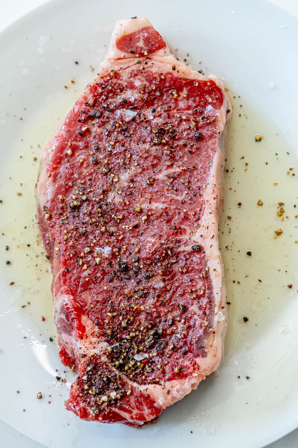 picture of a steak marinating in oil and spices