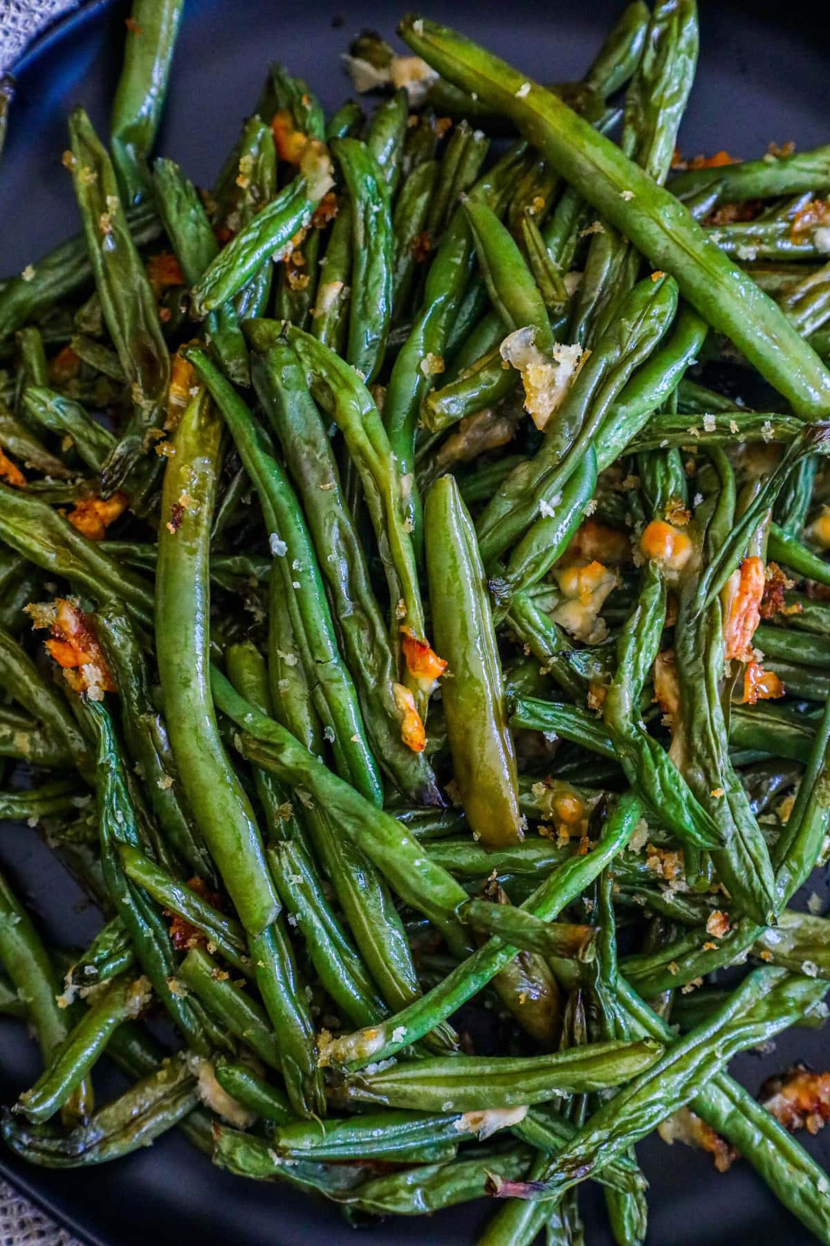 picture of parmesan roasted green beans on a black plate on a table