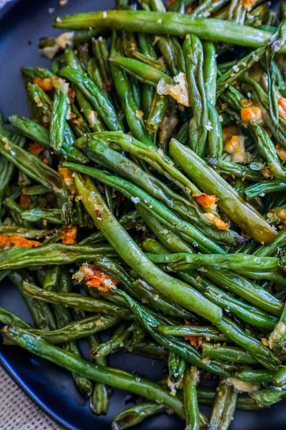 picture of parmesan roasted green beans on a black plate on a table