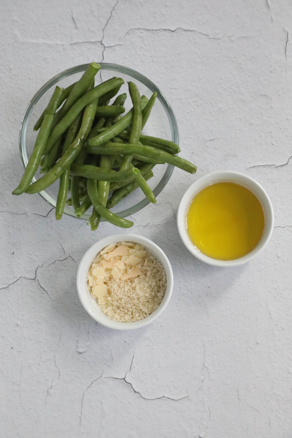 A bowl of Parmesan Roasted Green Beans served with olive oil.