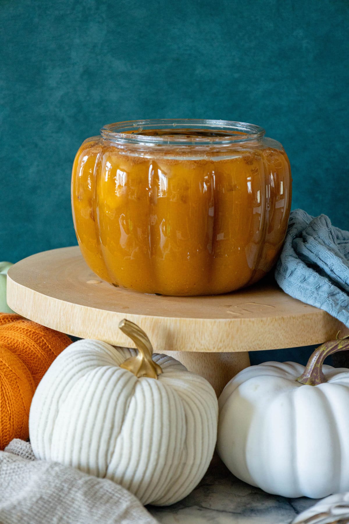 A jar of pumpkin butter displayed on a wooden stand.