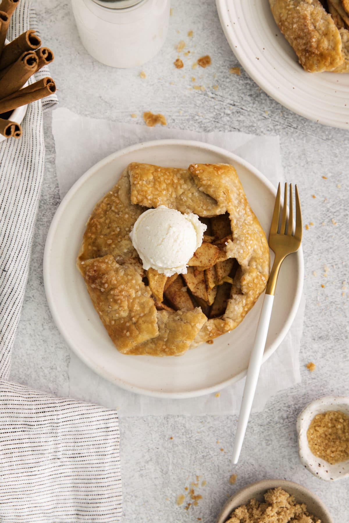 picture of apple galette on a table with a scoop of ice cream and a fork on the plate