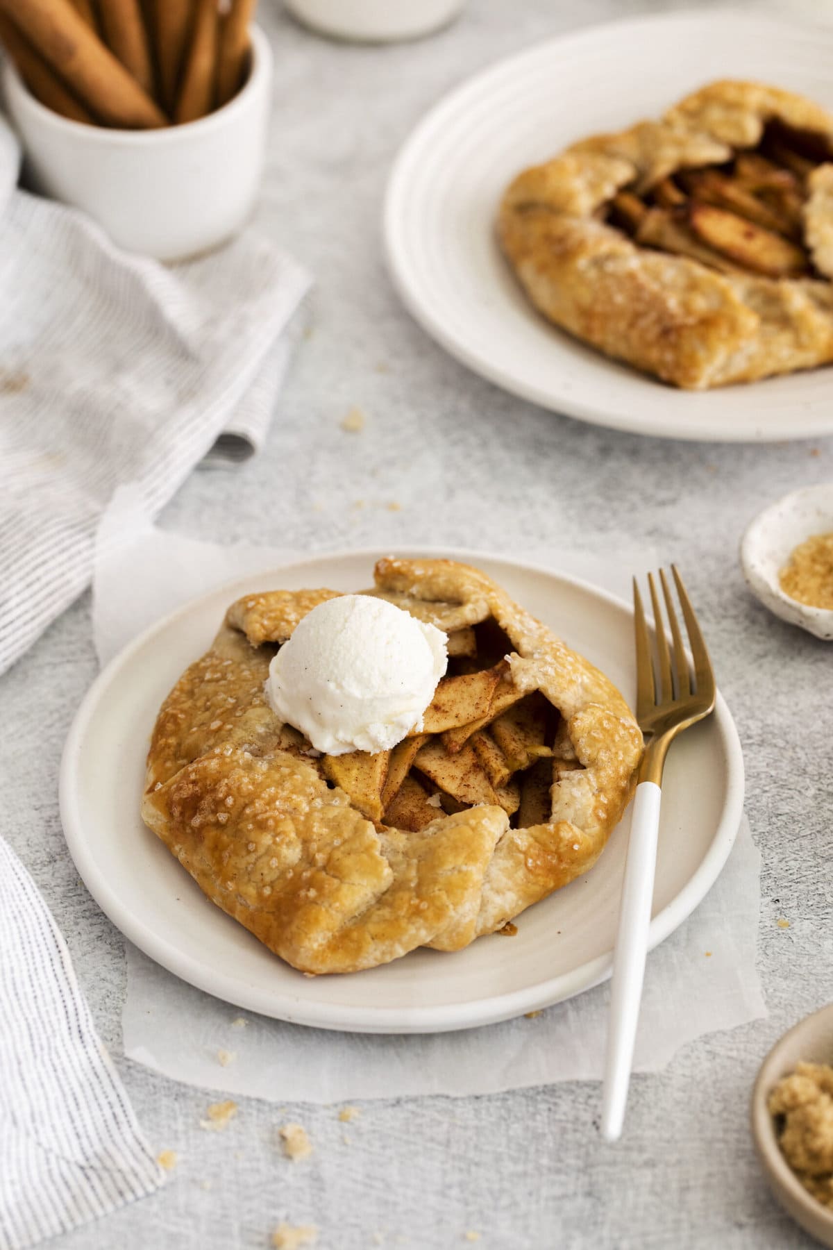 picture of apple galette on a table with a scoop of ice cream and a fork on the plate