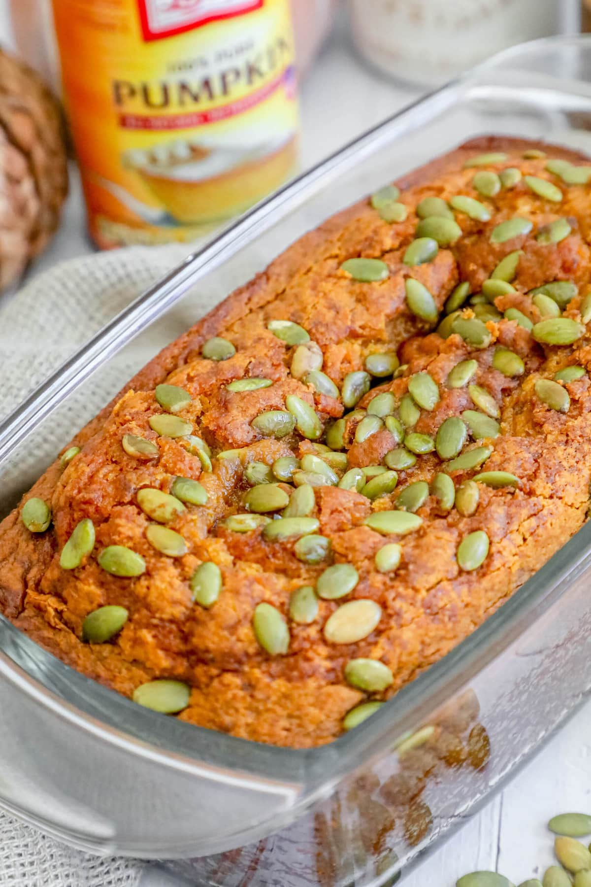 pumpkin bread with pumpkin seeds baked onto the top sliced on a table