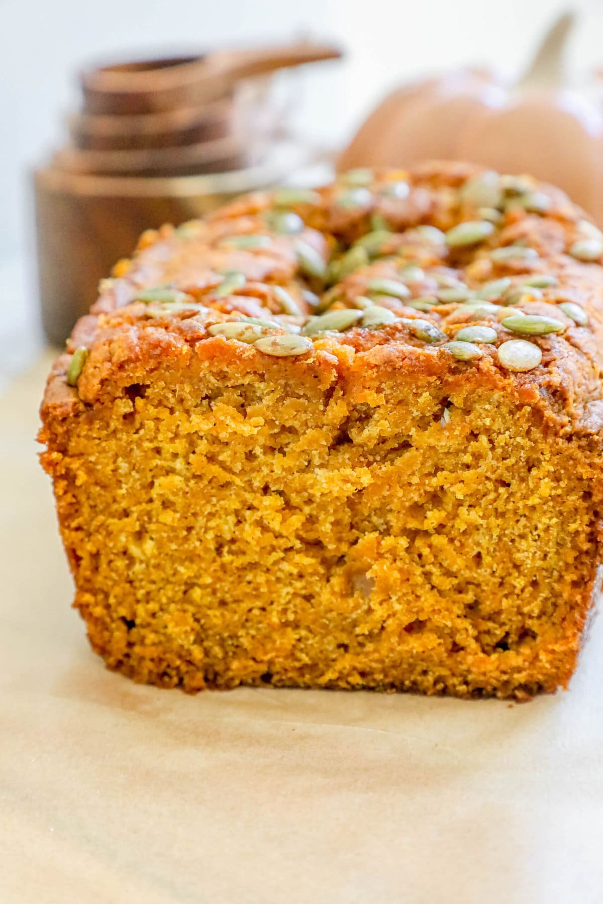 pumpkin bread with pumpkin seeds baked onto the top sliced on a table