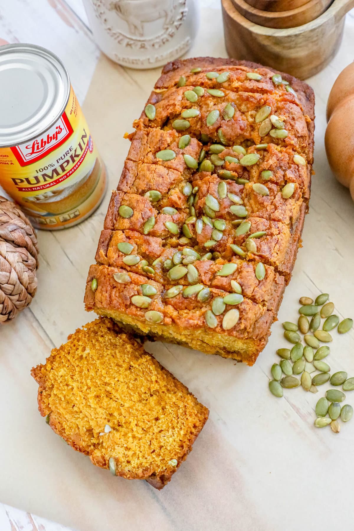 pumpkin bread with pumpkin seeds baked onto the top sliced on a table