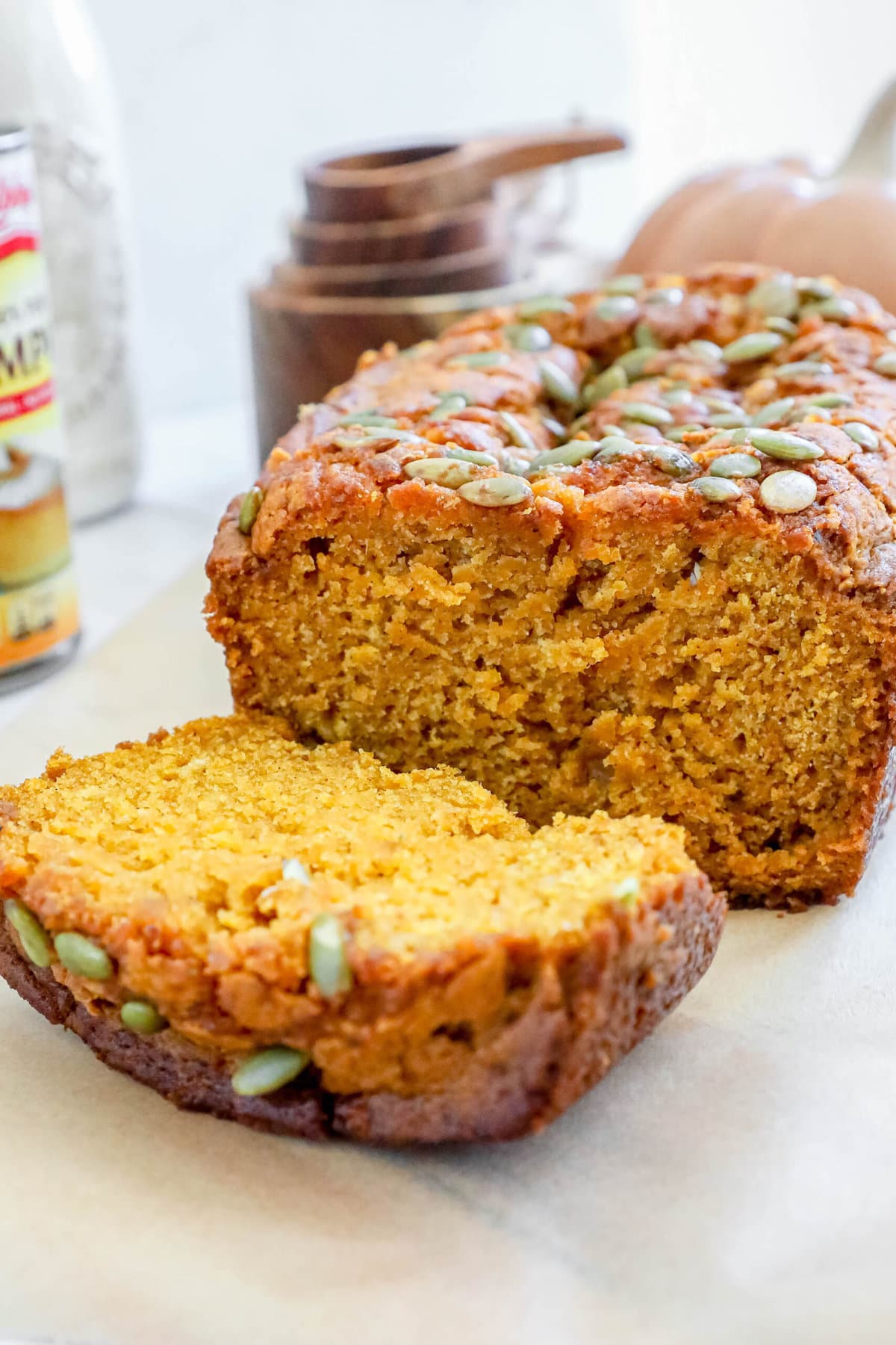 pumpkin bread with pumpkin seeds baked onto the top sliced on a table