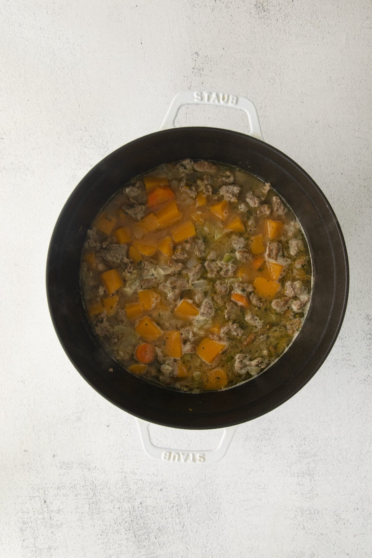 ground turkey with stock and sweet potatoes in a pot