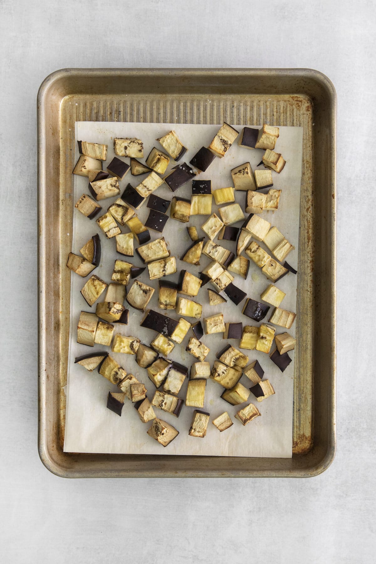 picture of roasted cubed eggplant on a baking sheet lined with parchment paper