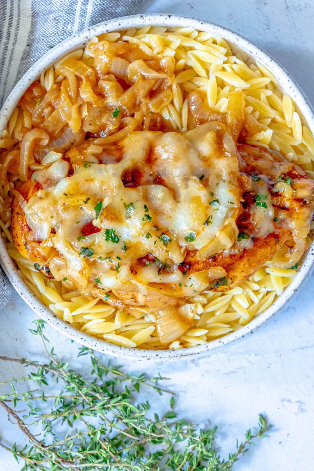 picture of chicken breast with melted cheese and browned french onions