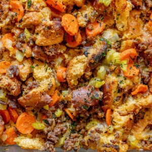 picture of cheeseburger stuffing in a glass tray on a table with carrots and herbs on top