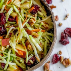 picture of cranberry slaw salad with pecans in a brown bowl on a table