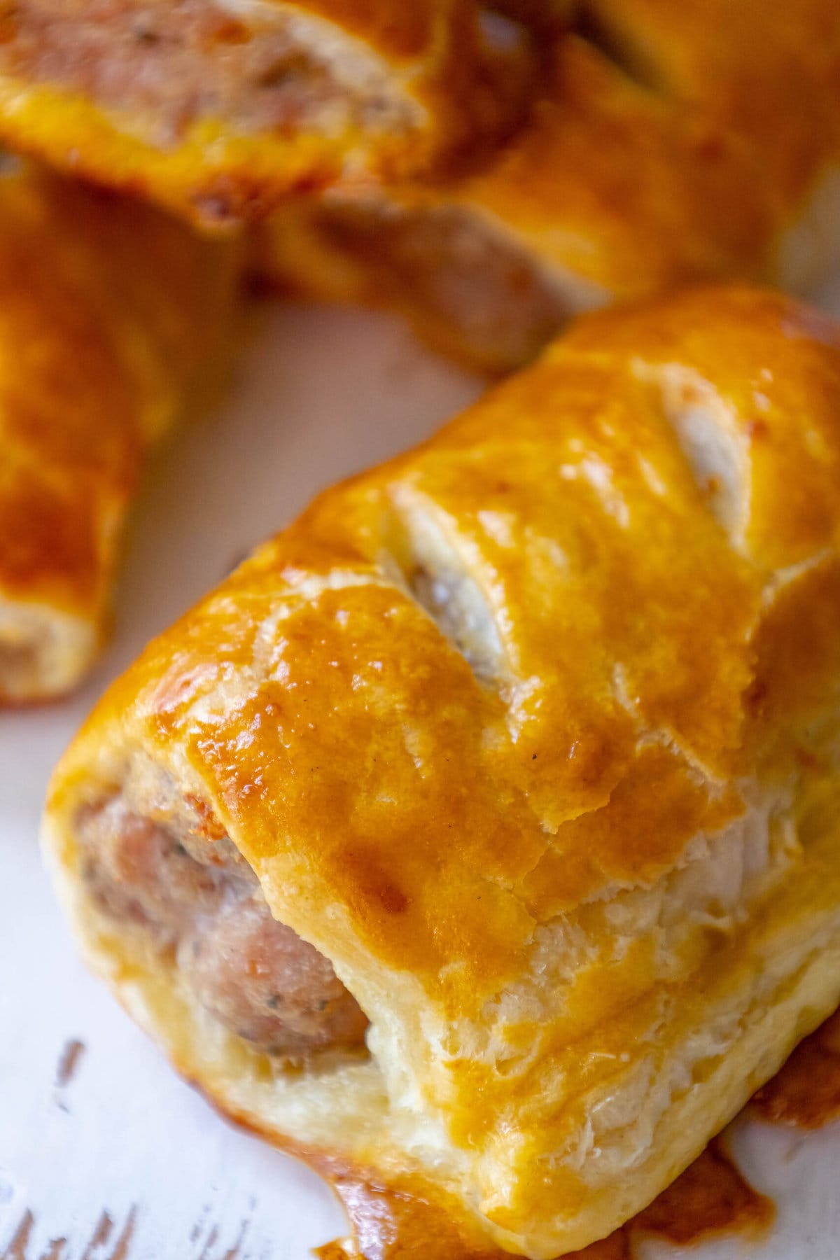 sausage rolls up close on a white cutting board
