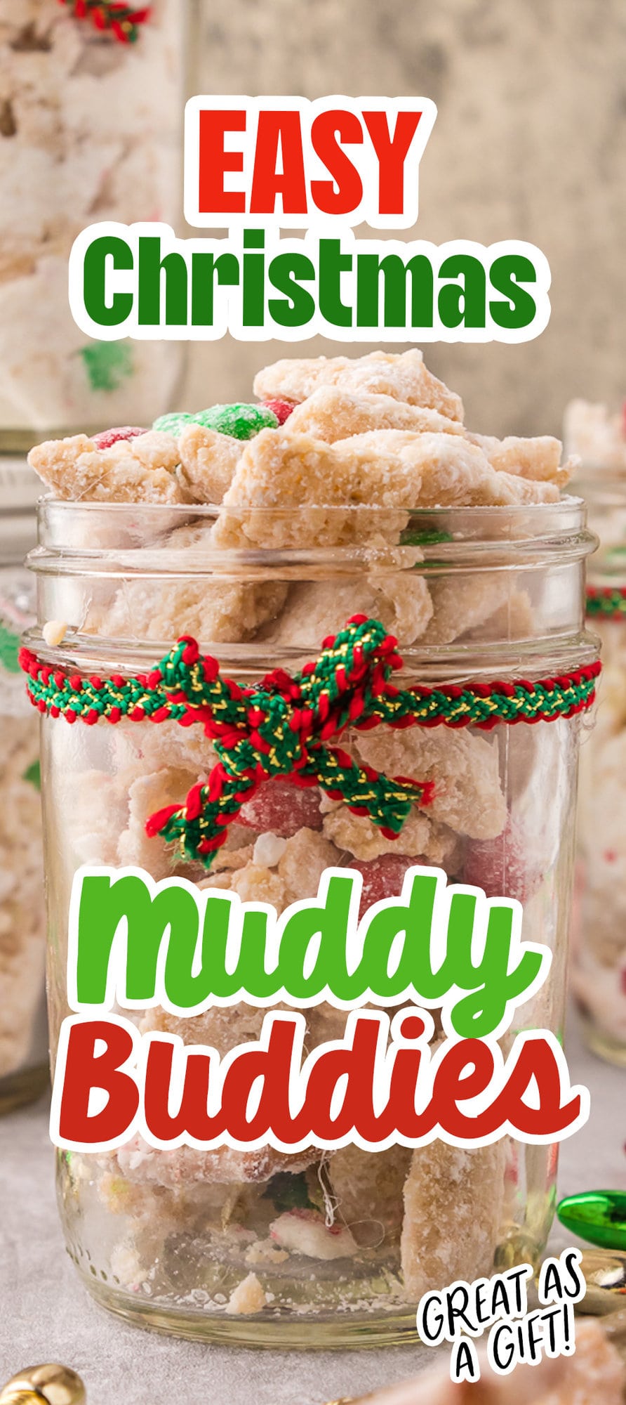 picture of muddy buddies chex mix with pretzels and red and green candies mixed in coated in powdered sugar in a jar with a red and green bow on it 