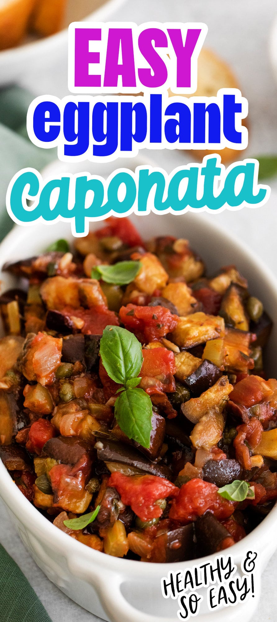 picture of baked eggplant caponata in a white dish with basil leaves on top on a table next to a spoon