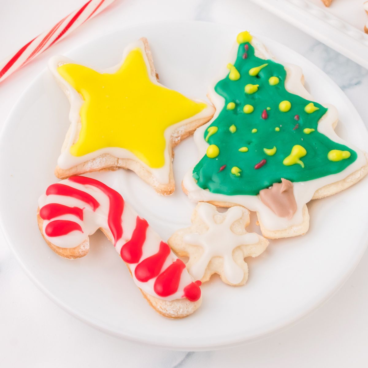 picture of iced christmas cookies on a white plate on a table