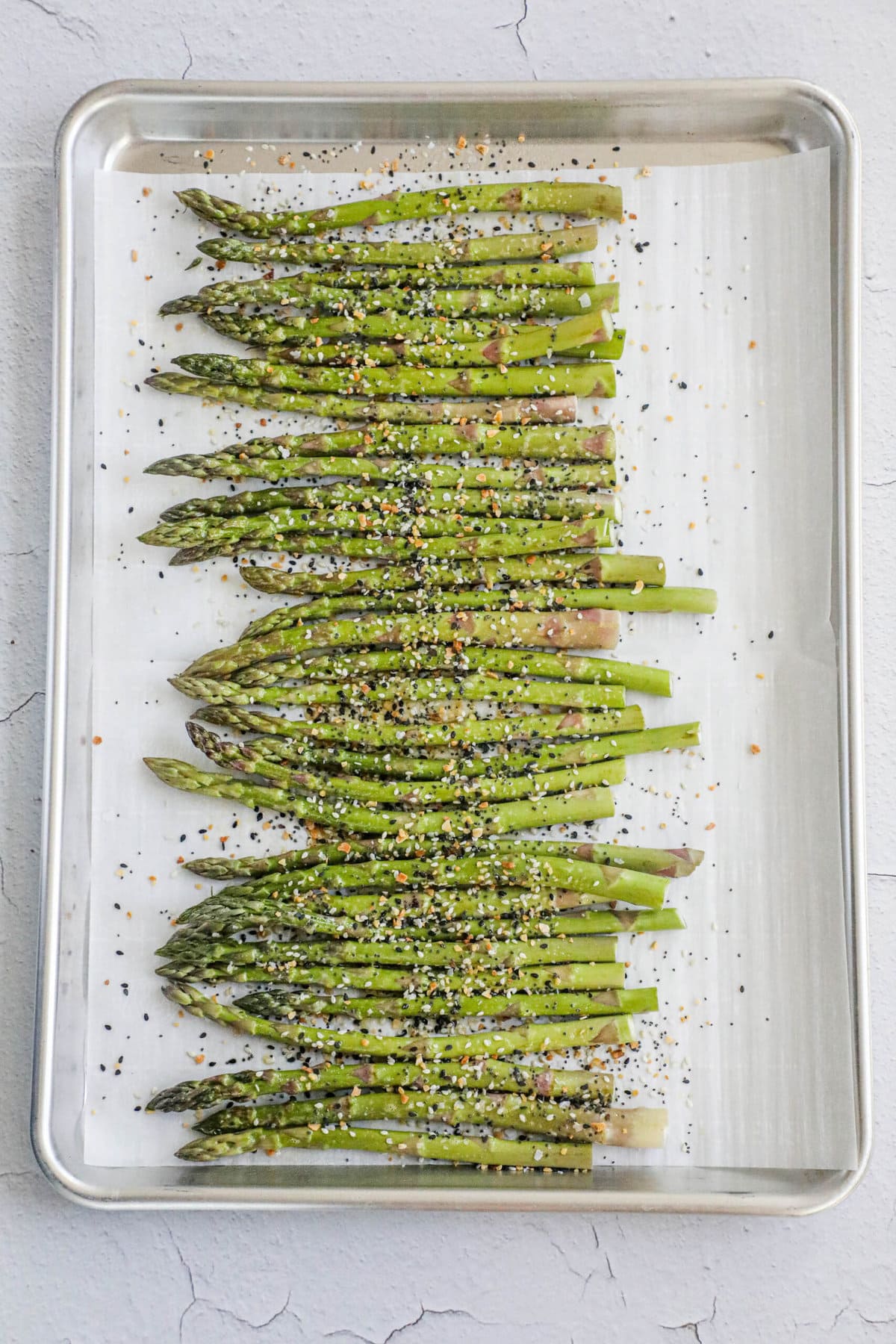 picture of asparagus spears on a baking sheet lined with parchment paper