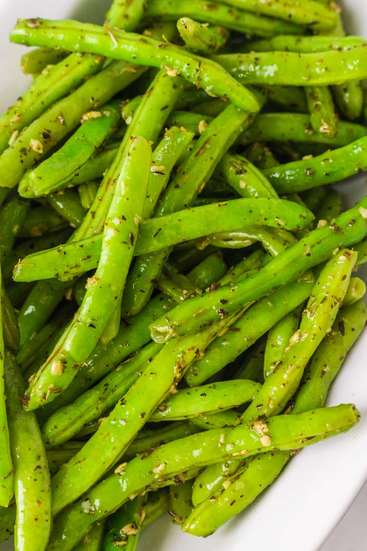 picture of green beans seasoned with garlic and herbs in a bowl 