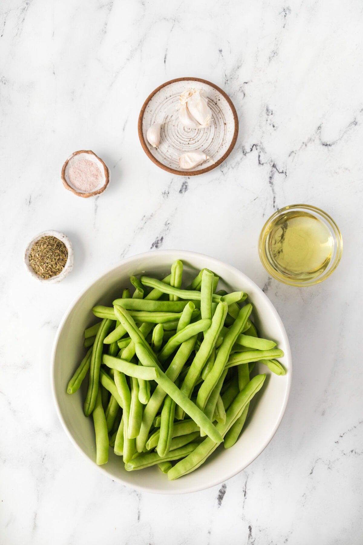 Green beans with sauteed garlic on a marble table.