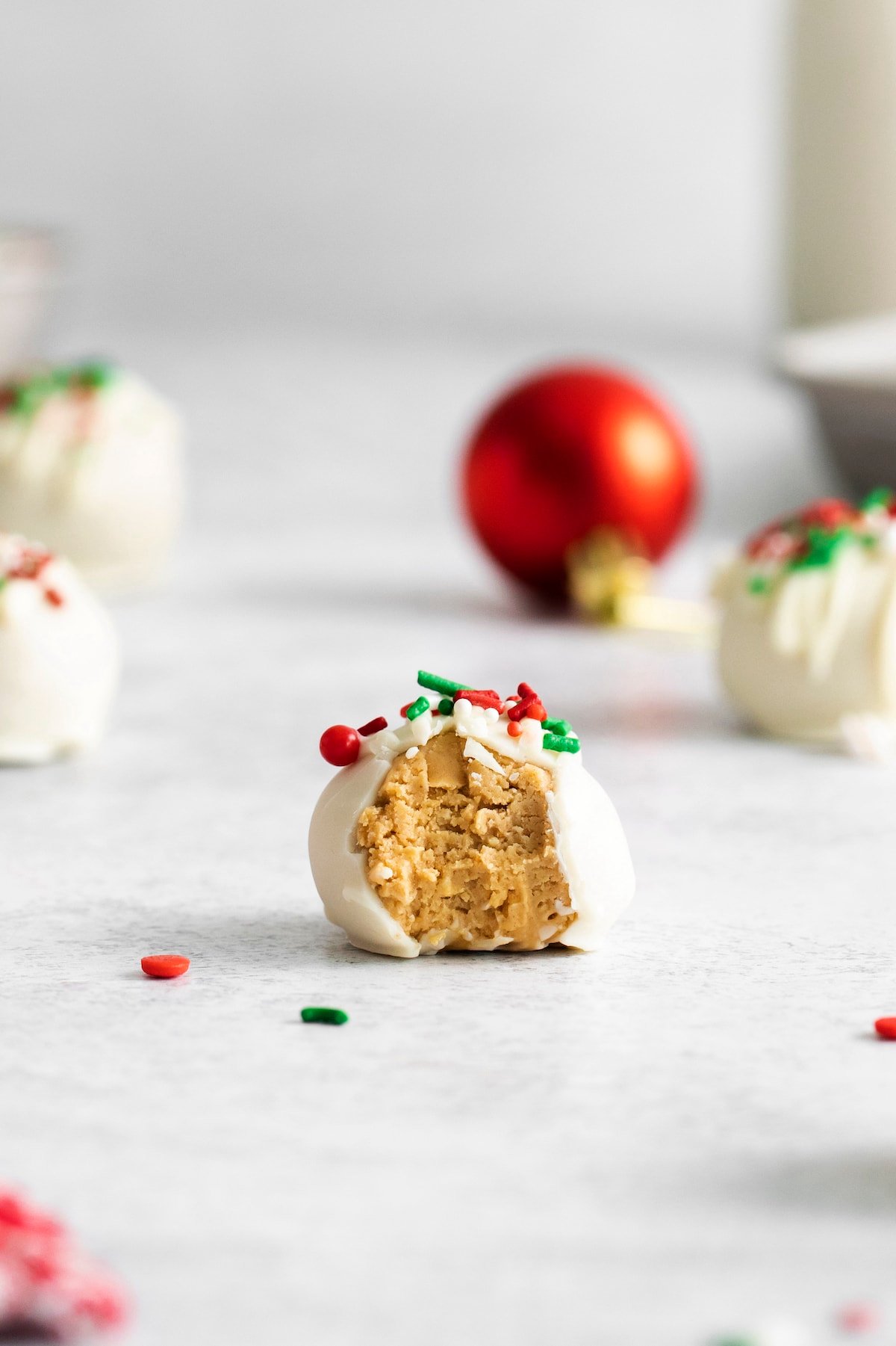 picture of a peanut butter truffle coated in white chocolate on a table with a bite taken out of it