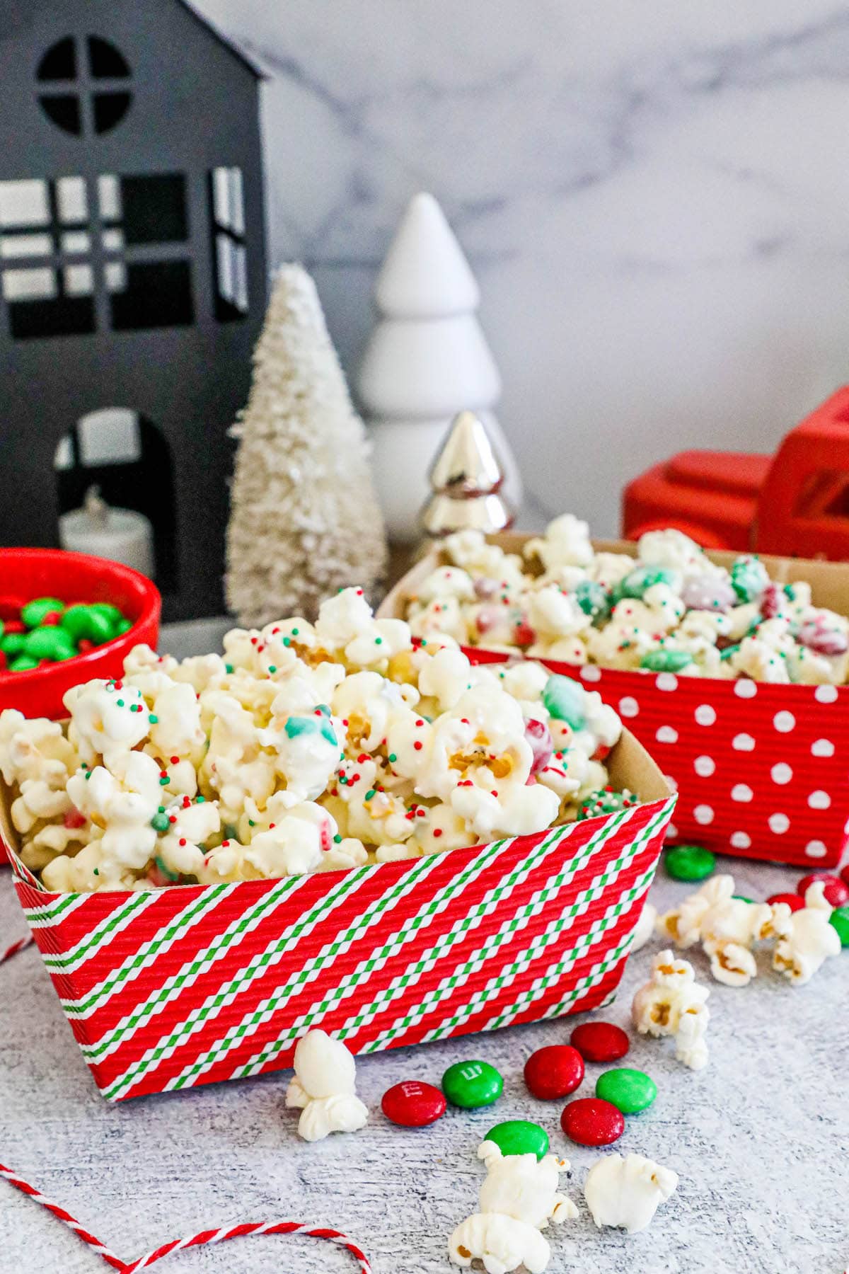 popcorn with canides in it in a striped box on the counter. 