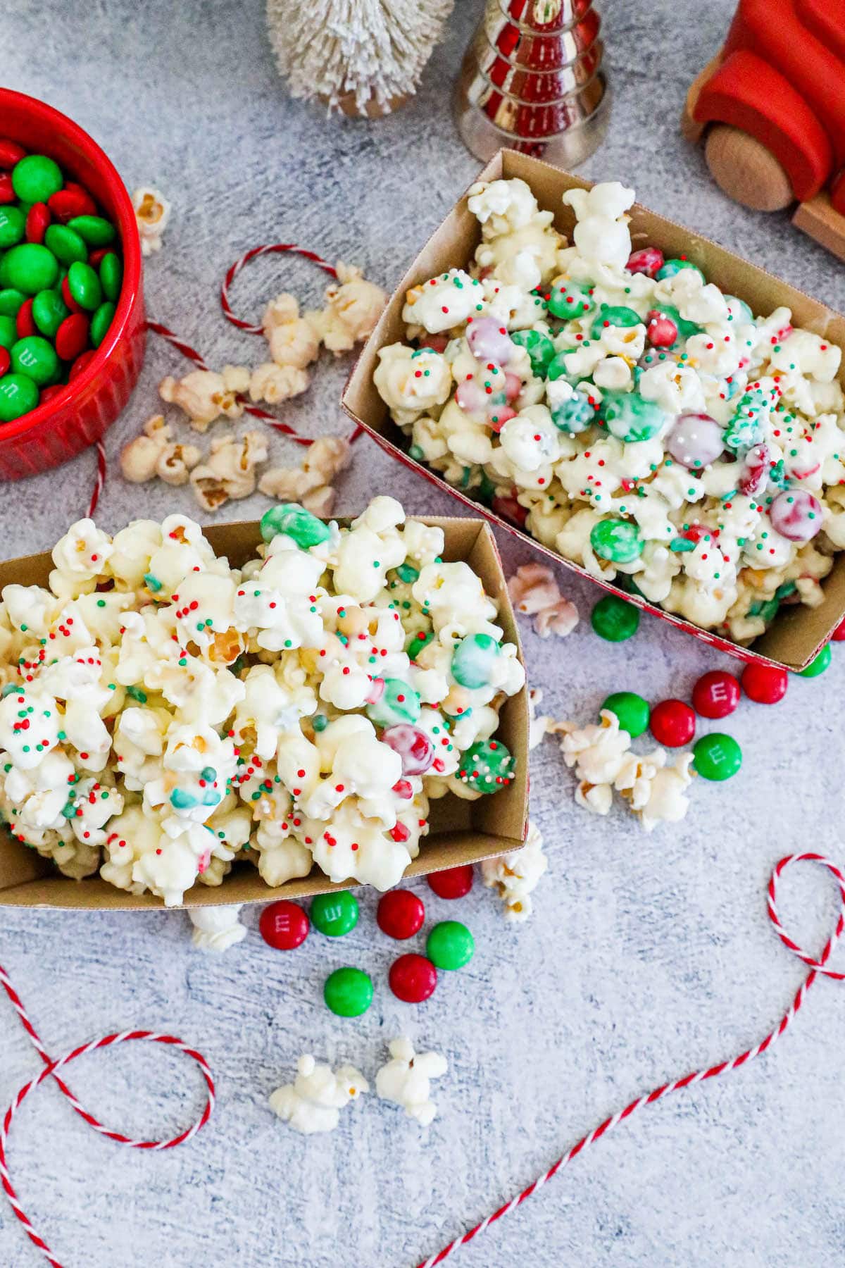 two bins of chocolate popcorn with sprinkles and candies