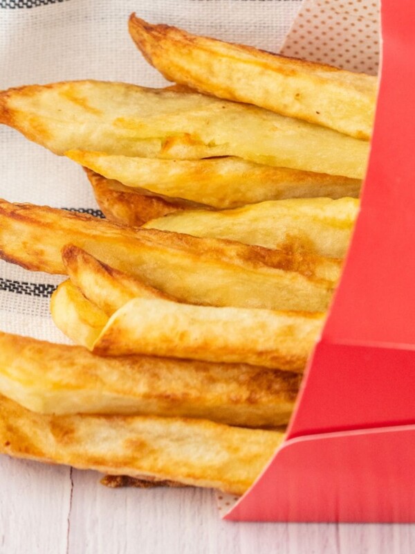 french fries in a red paper sleeve on a table