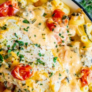 A bowl of pasta with egg and tomatoes.