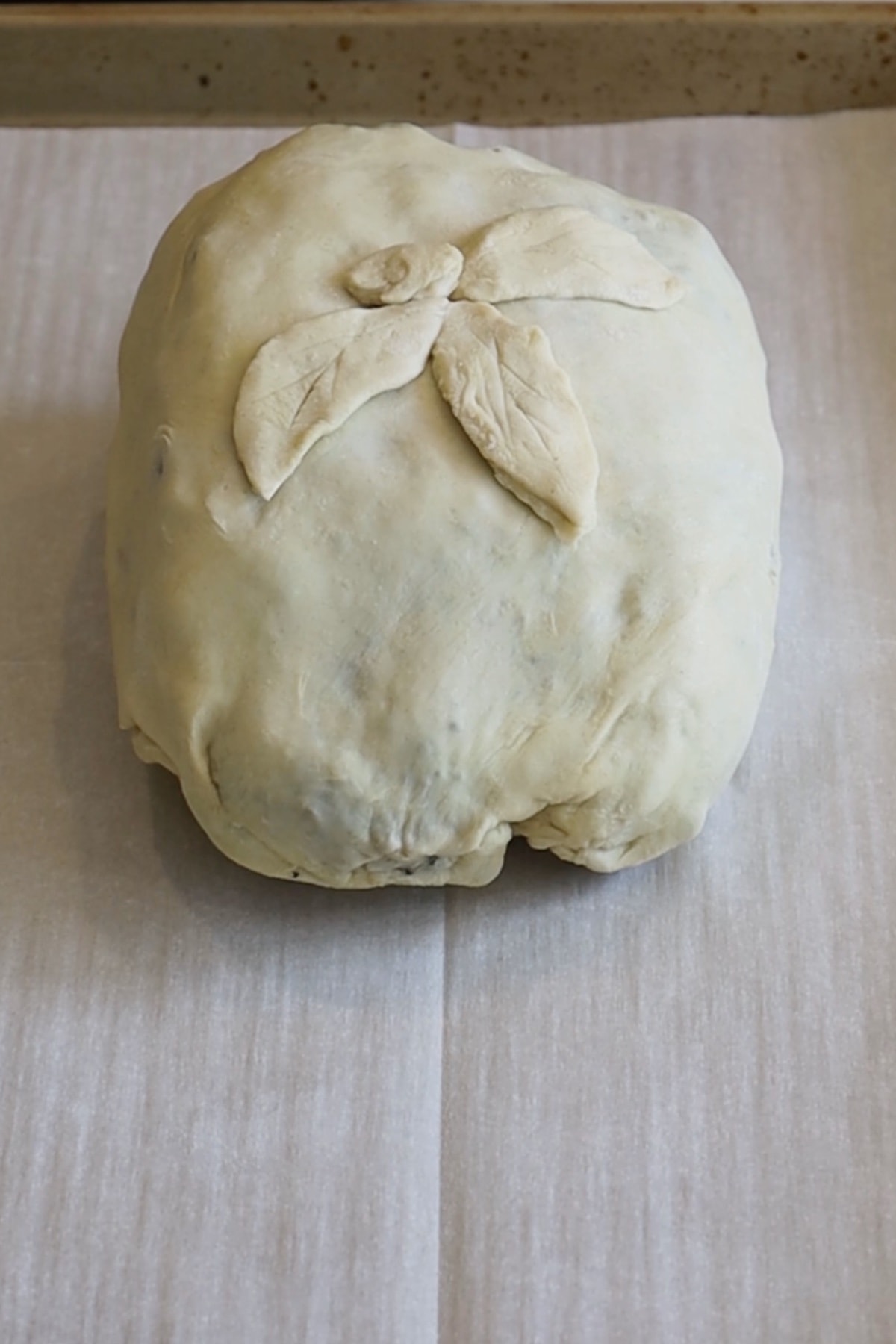 uncooked beef wellington in raw puff pastry on a baking sheet lined with parchment paper