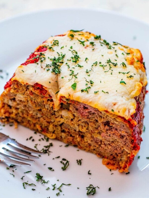 meatloaf loaf covered in cheese and basil with a fork
