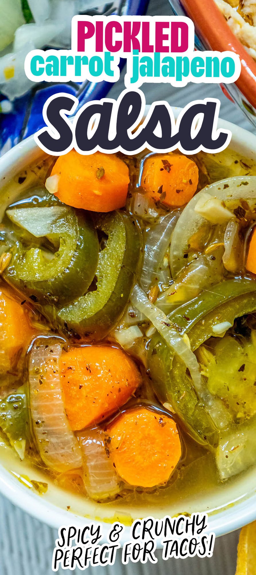 a bowl of pickled sliced carrots and jalapenos with onion slices on a table