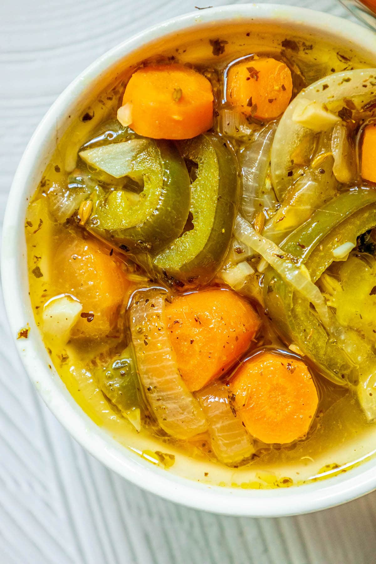 a white bowl with sliced pickled carrots and jalapenos