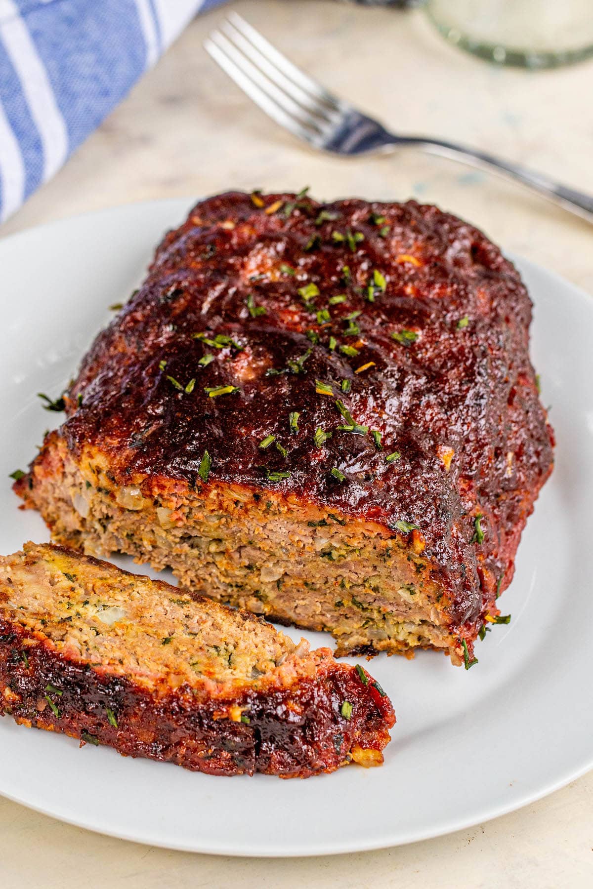 smoked meatloaf on a white plate with one slice sliced