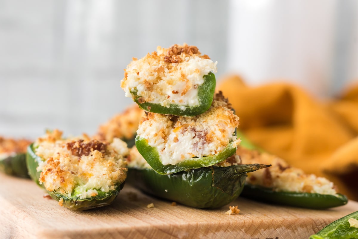 air fried jalapeño peppers sliced in half stuffed with cream cheese mixture and bread crumbs stacked on top of each other