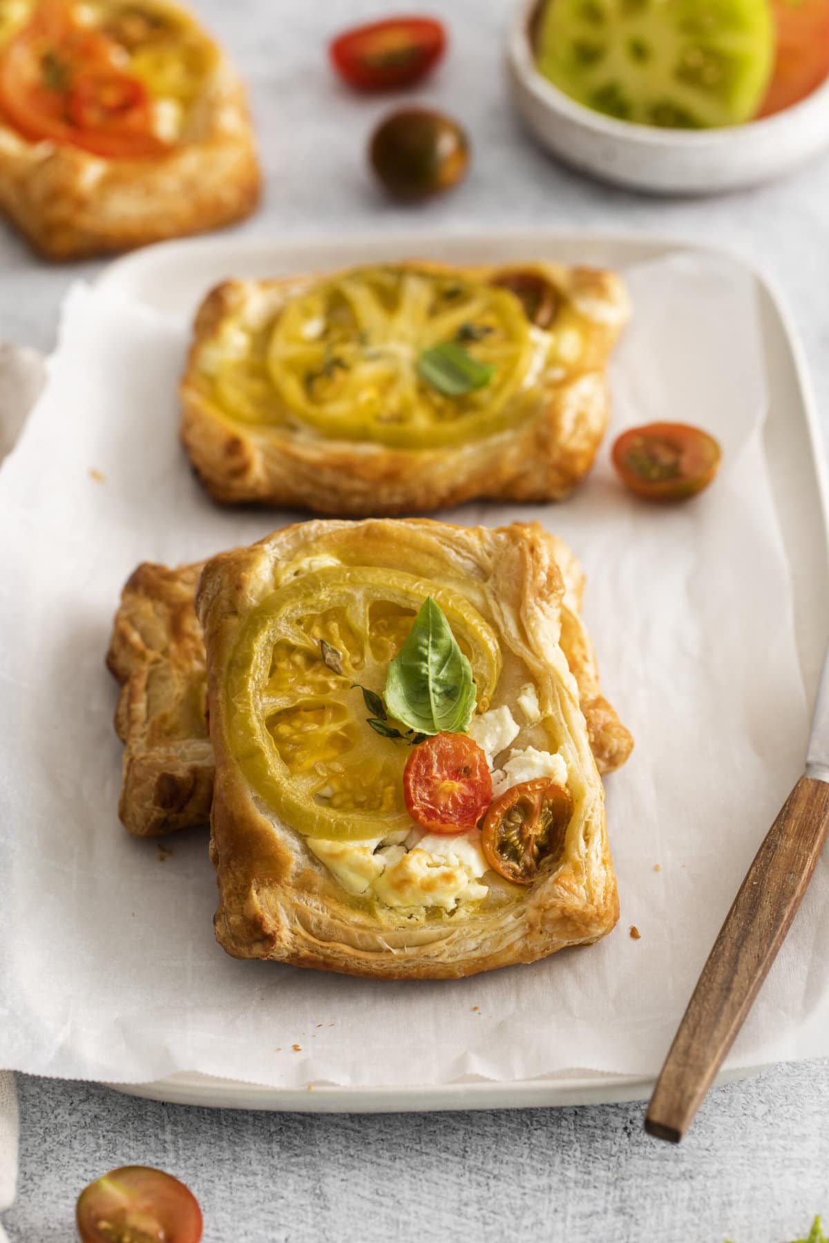 three tomato cheese tarts on a piece of parchment paper