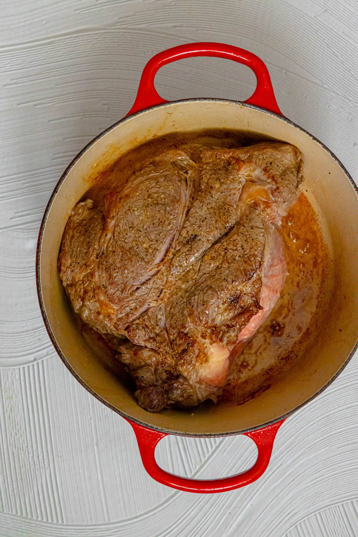 browned pot roast in a dutch oven
