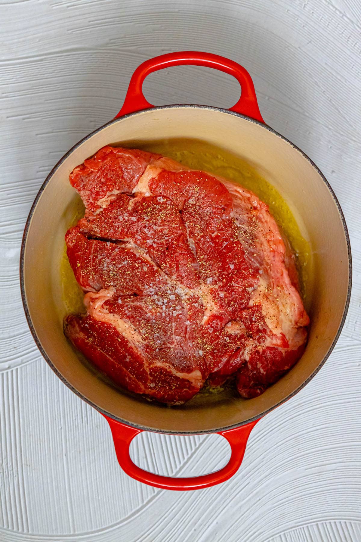 raw pot roast in a dutch oven