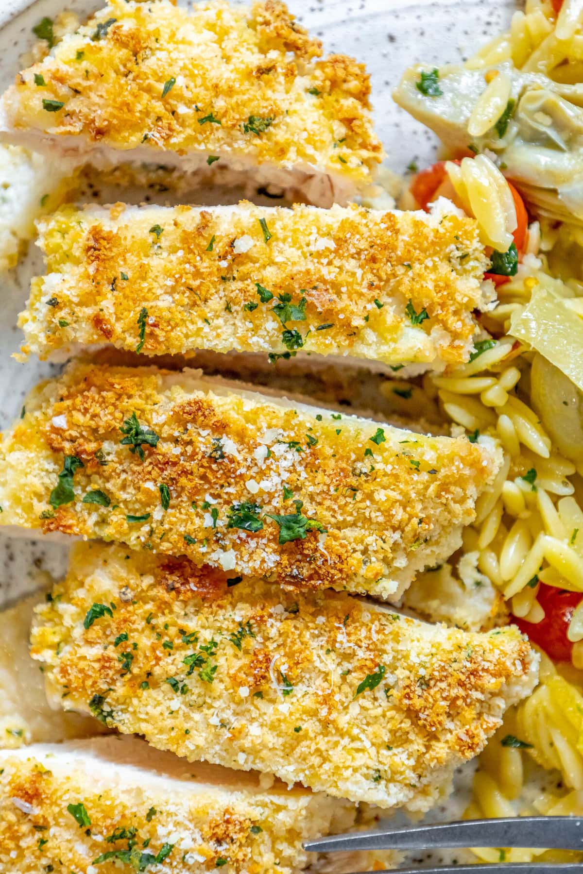 breaded chicken breast on top of orzo pasta