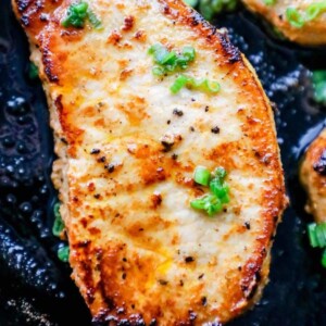 baked pork chop with minced chives in a pan