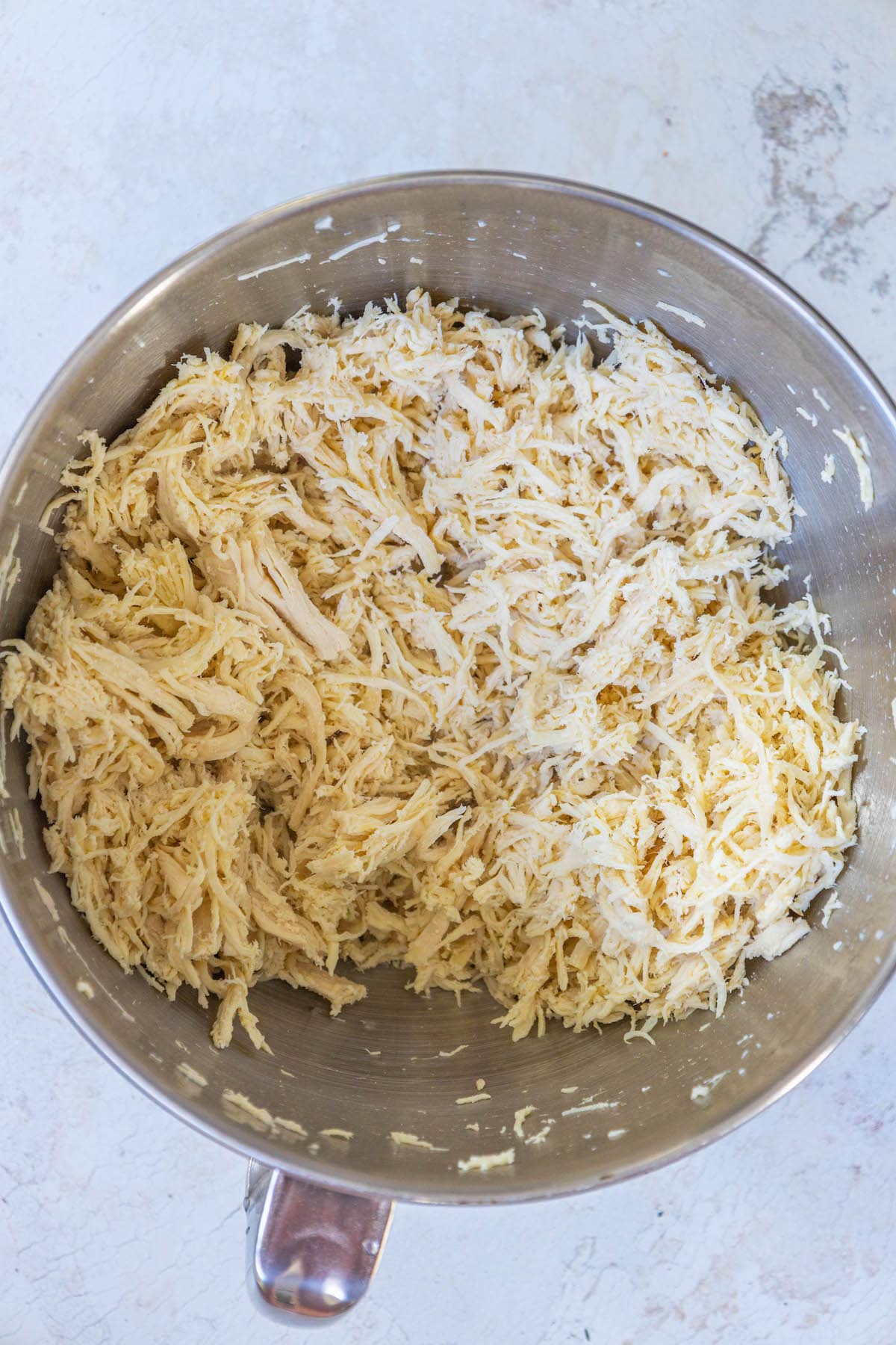 shredded chicken in a stand mixer bowl