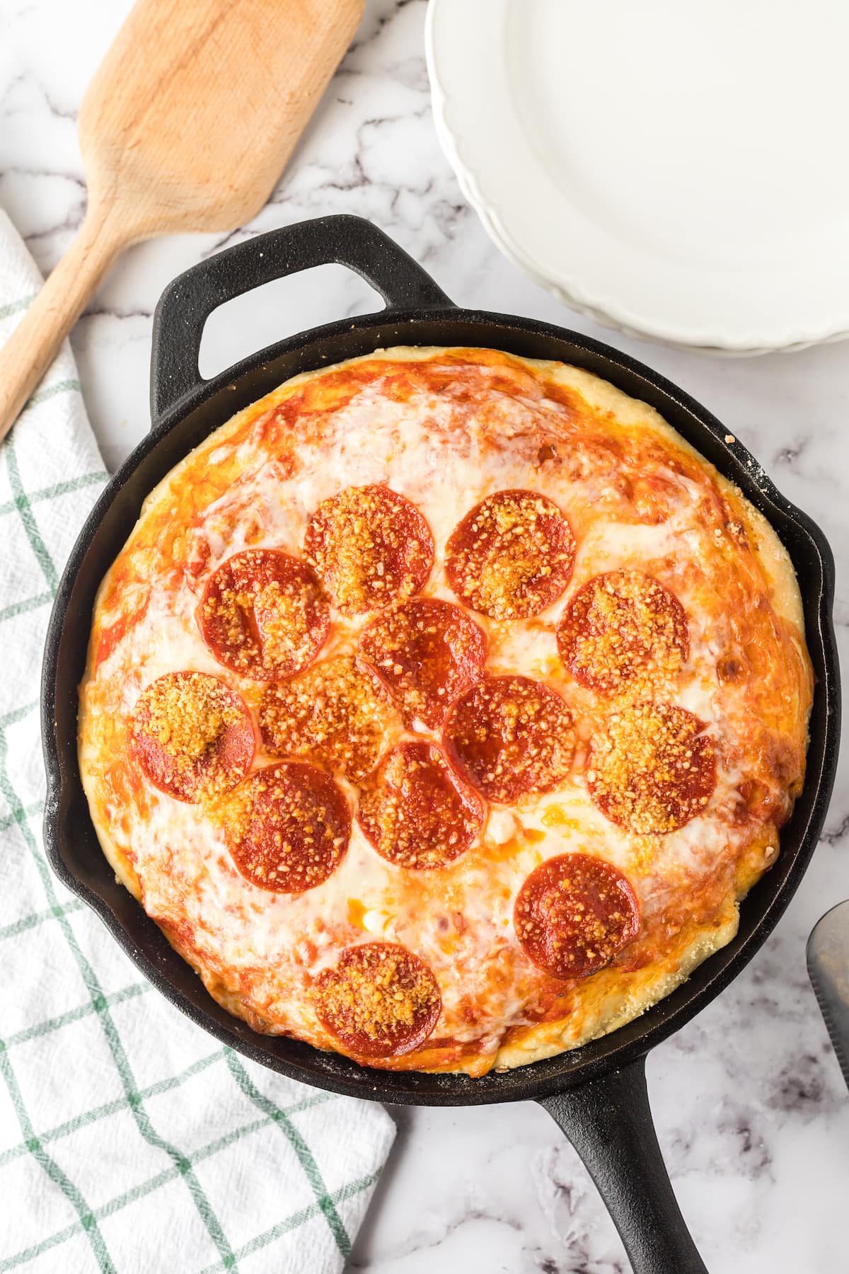 baked deep dish pizza in a cast iron skillet on a table