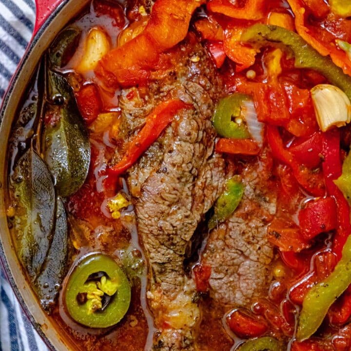 pot roast in a dutch oven with bell peppers and jalapeños and stock