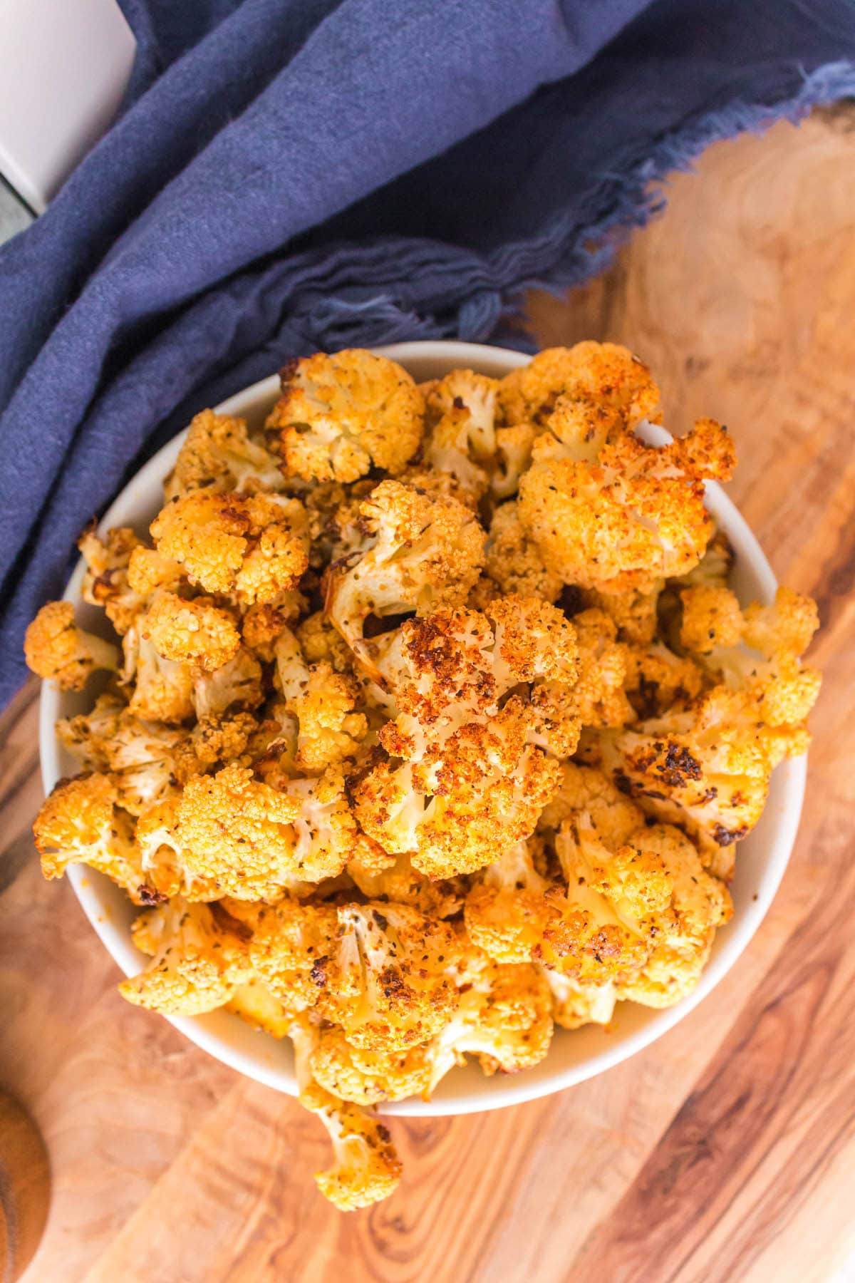 browned seasoned cauliflower in a white bowl on a table