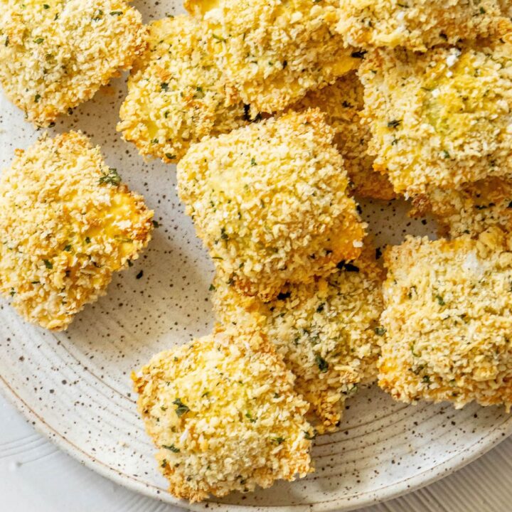 crunchy baked breaded ravioli on a white speckled plate