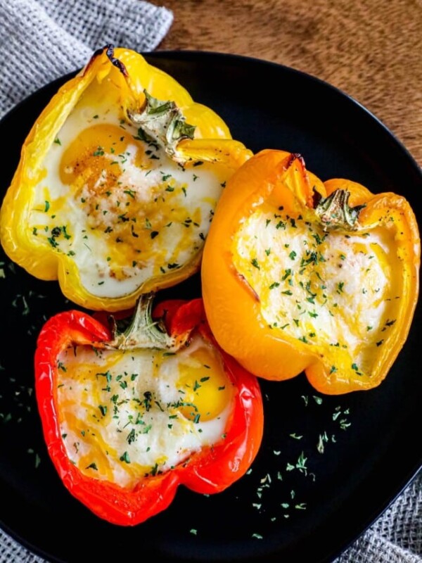 bell peppers with an egg baked into the center and parsely on them.