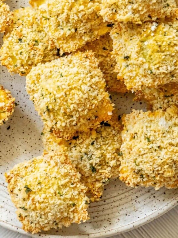 crunchy baked breaded ravioli on a white speckled plate